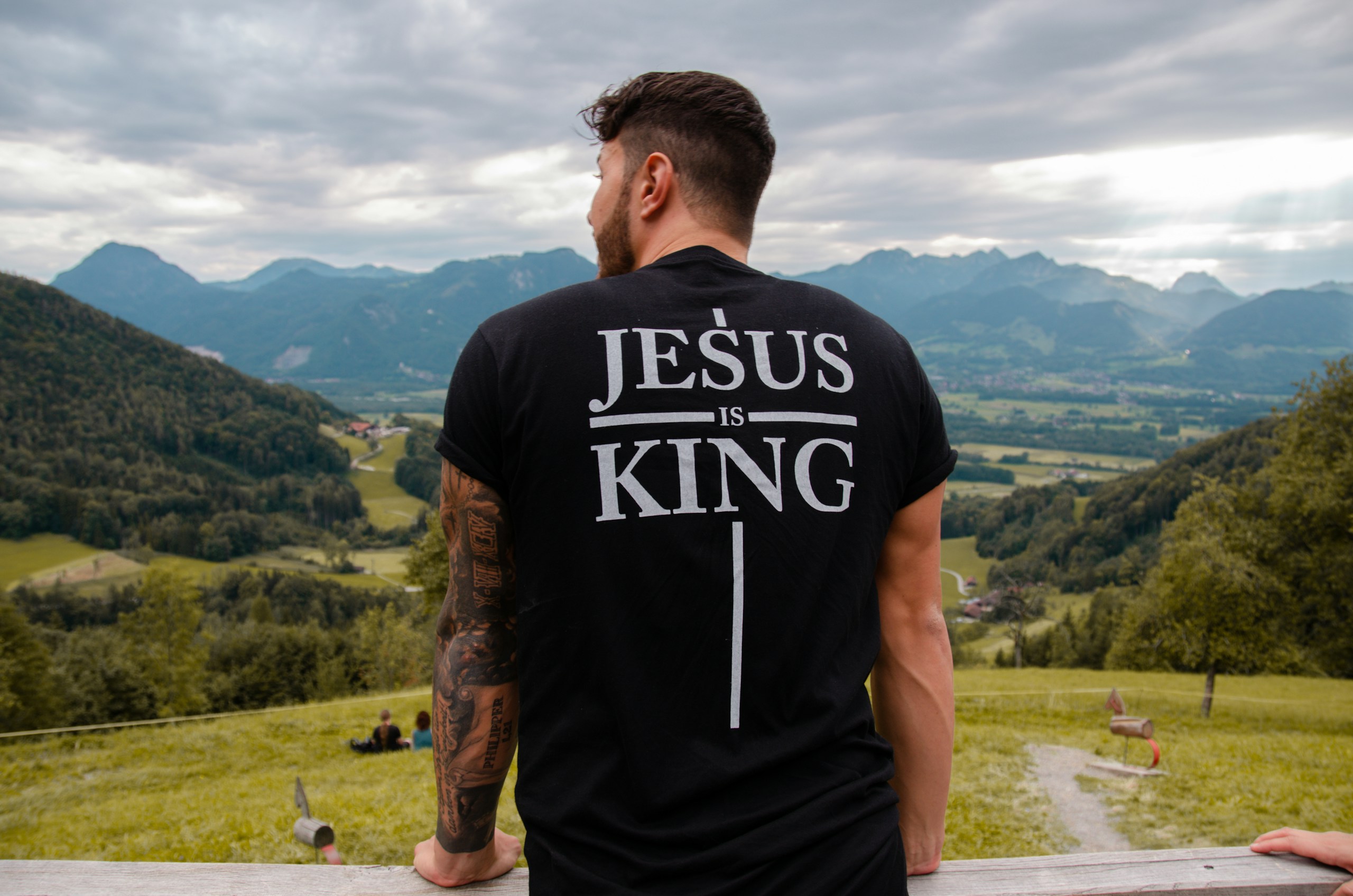 Christian man wearing a Jesus is King t-shirt while looking out at the nature in Germany.